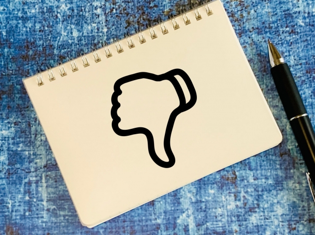 サムズダウンのイラストが描かれたメモ