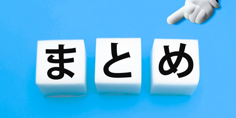 青い背景の上に白い立方体ブロック3つが並び、黒文字で ‘ま’ ‘と’ ‘め’ と書かれ、右上から白い手が指し示しているビジュアル