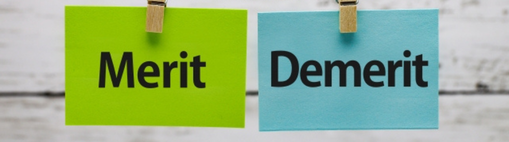 緑と水色のカードに書かれた「Merit」と「Demerit」の文字がクリップで吊るされた構成