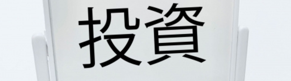 ホワイトボードスタンドに表示された「投資」の文字が際立つシンプルな構成