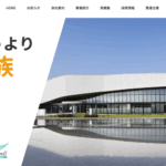 那須建設株式会社のトップページ、「会社というより大家族」のキャッチコピーとモダンな建物外観のイメージ