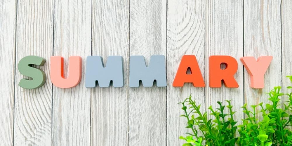 木目の背景に「SUMMARY」と並んだカラフルなアルファベット。右下には緑の観葉植物が添えられている。