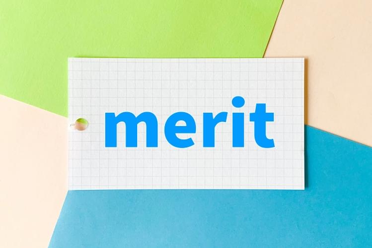 「merit」と書かれたカードがカラフルな背景に置かれた、利点や強みを表現するイメージ