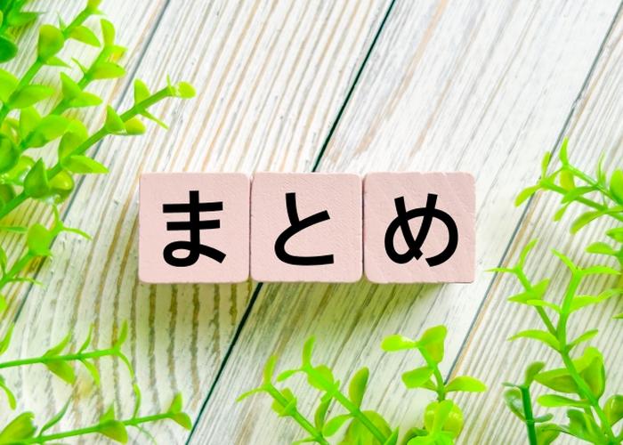 「まとめ」と書かれたピンクの木製ブロックとナチュラルな木目背景、植物に囲まれた締めくくりのイメージ
