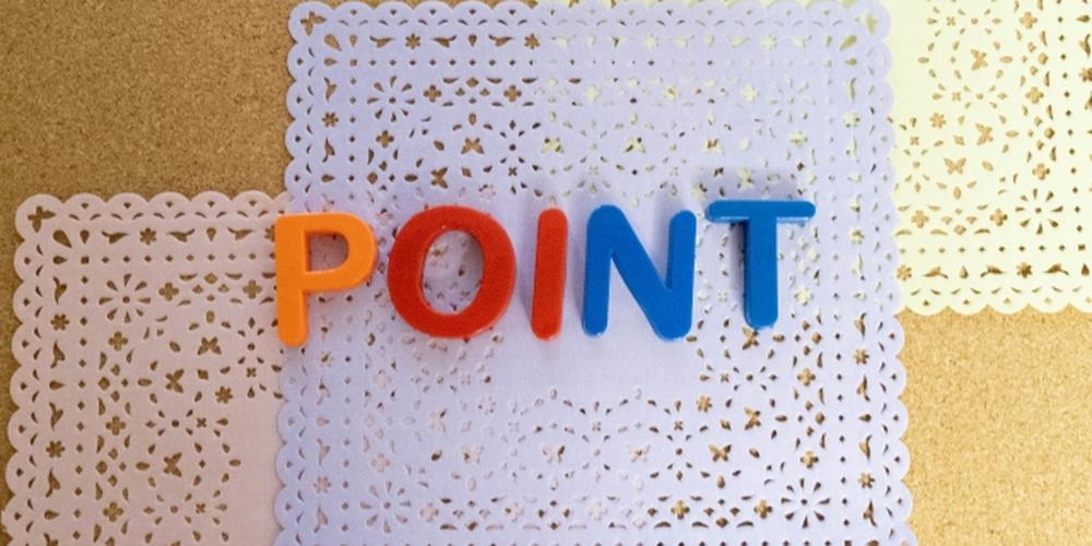レース模様の紙の上にカラフルな文字で並べられた「POINT」