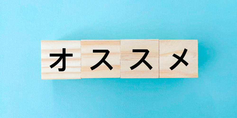 パステルブルーの背景に木製ブロックで『オススメ』と並べた写真