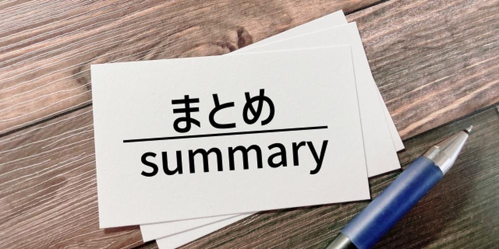 木目背景に置かれた「まとめ summary」と書かれたカードとペンのイメージ写真